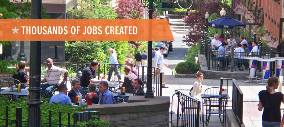 People dining outside in different sidewalk areas, banner with text: "Thousands of Jobs Created"