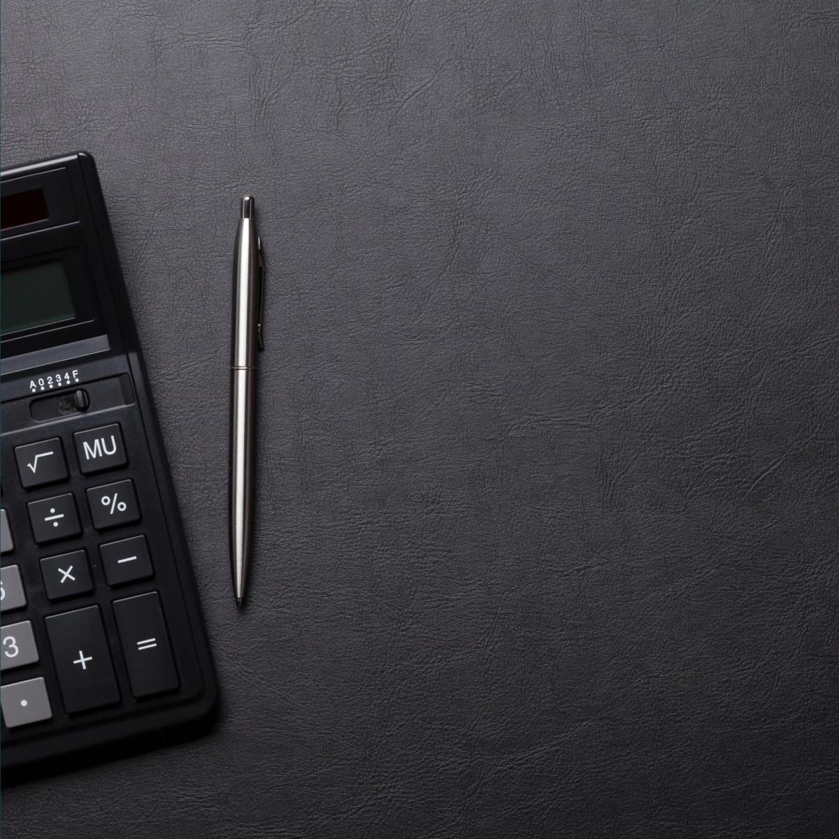 Dark photo of calculator and pen