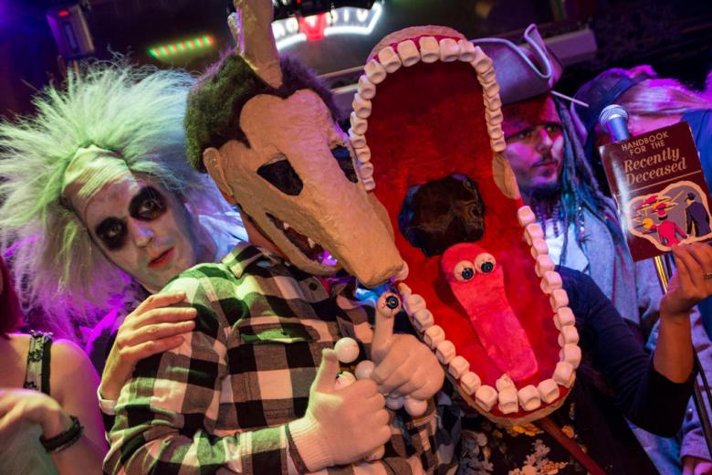 A trio of adults in halloween costumes representing characters from the Beetlejuice movie