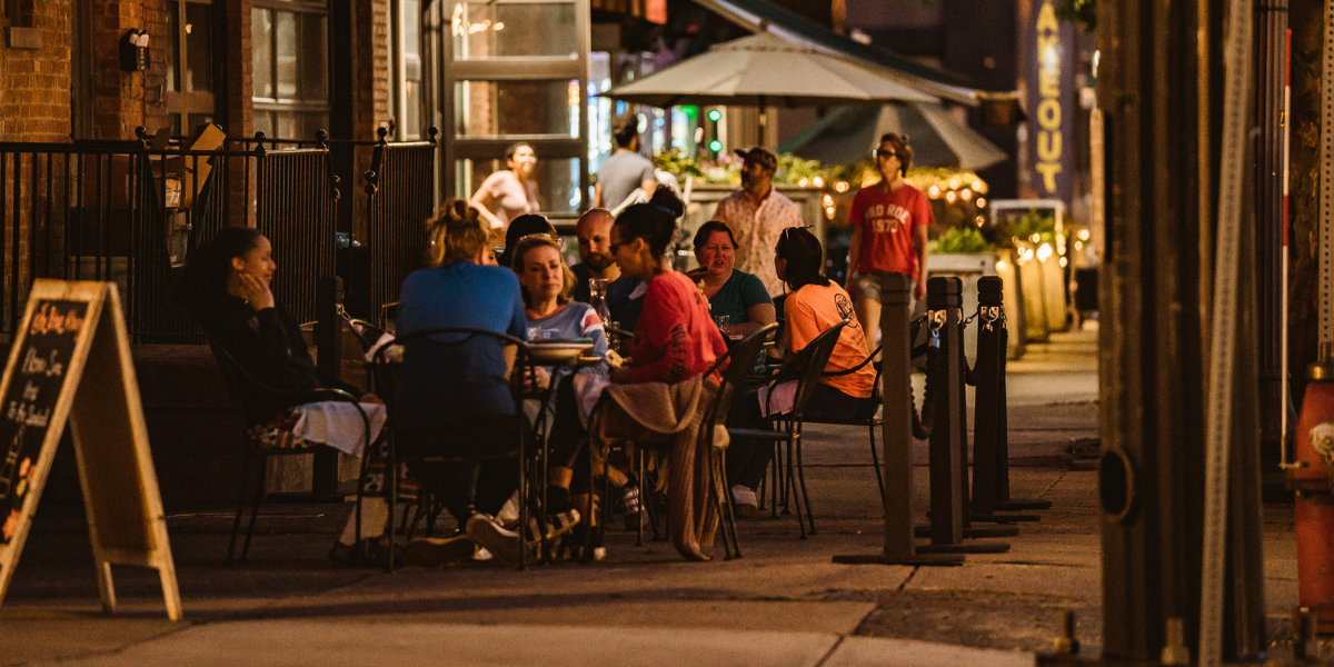 People sit on patio on downtown Albany street