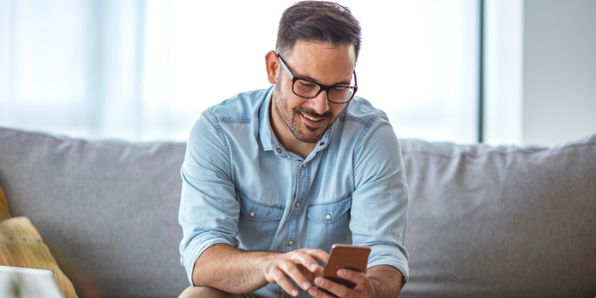 Man sitting on couch and looking at phone 