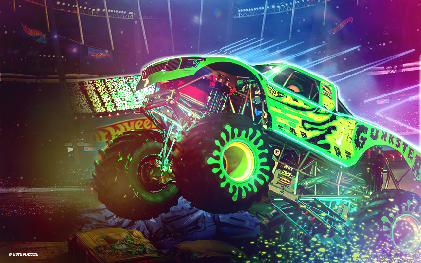 Photo of glow in the dark Monster Truck jumping over obstacles.