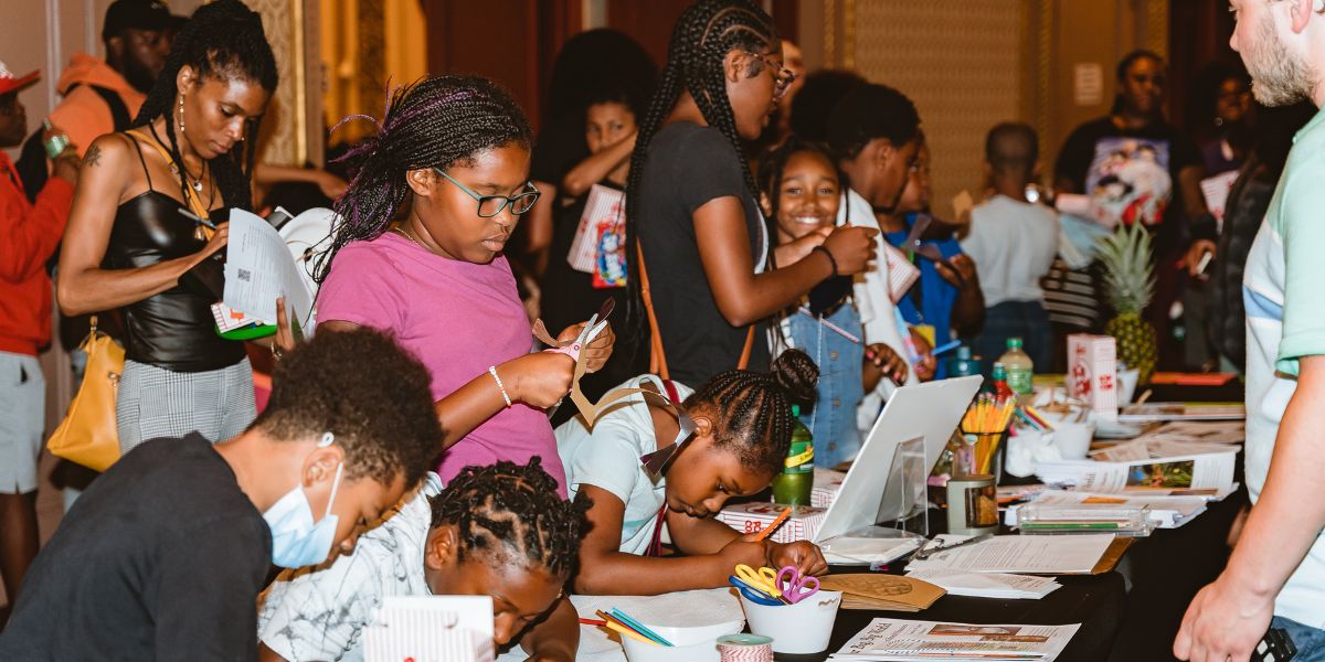 Kids and adults at table participating in coloring activity