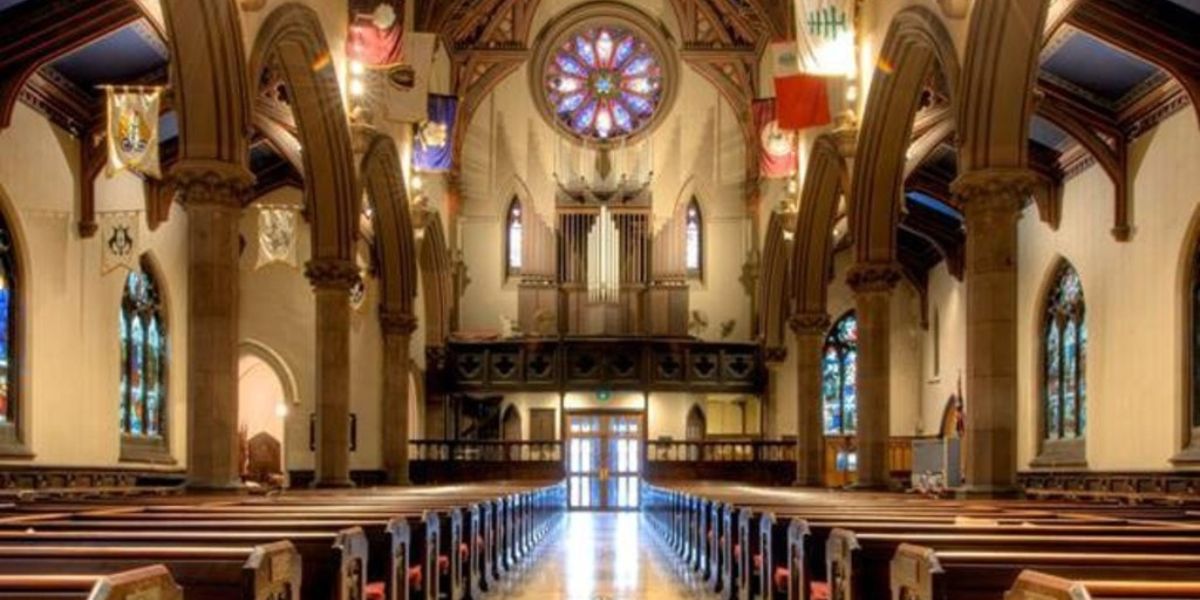 Church pews look out onto entrance with columns at left and right sides.