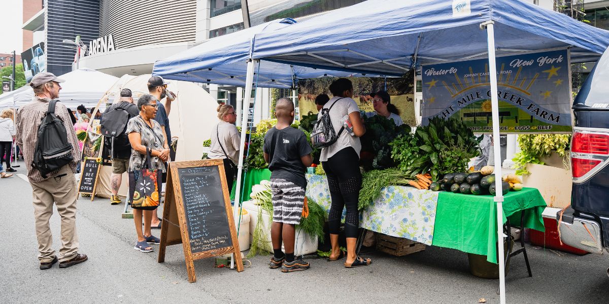 People stand in line for produce at farmers market