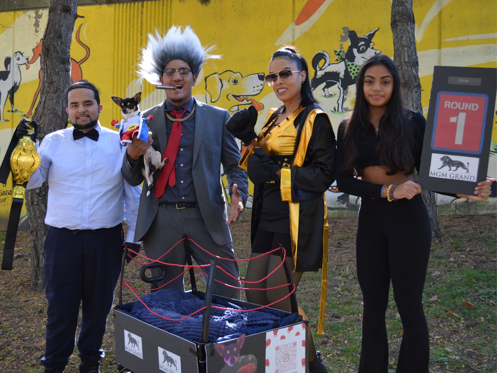 Four adults stand in line with one man holding a dog