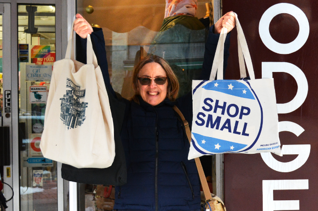 Woman holding up two large tote bags.