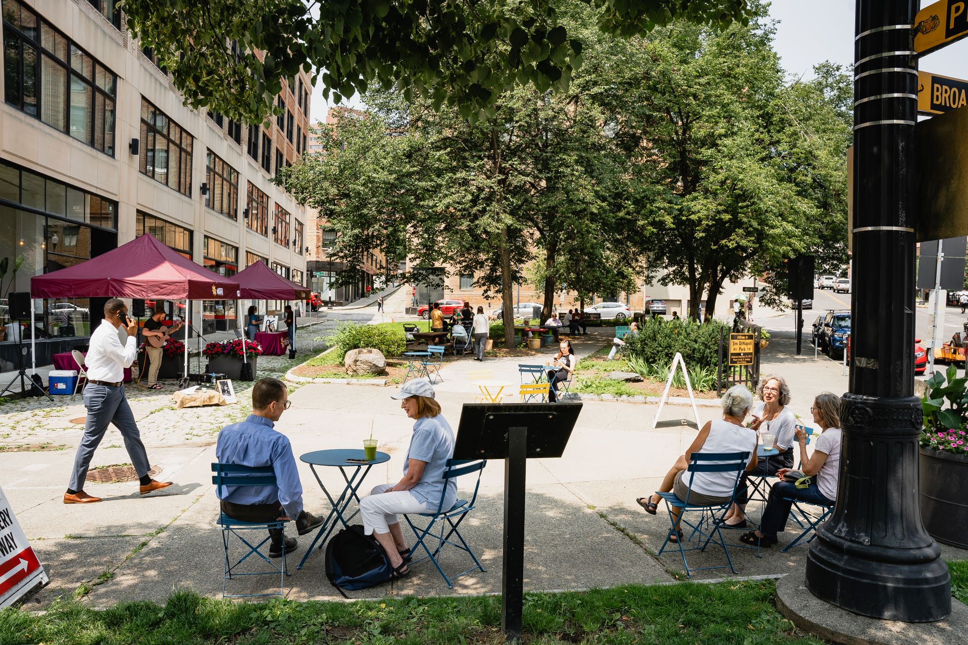 People gather in a park to listen to live music while eating lunch.