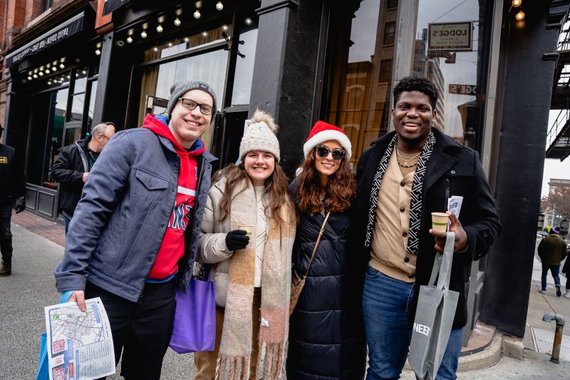 People at hot chocolate stroll outside with mugs
