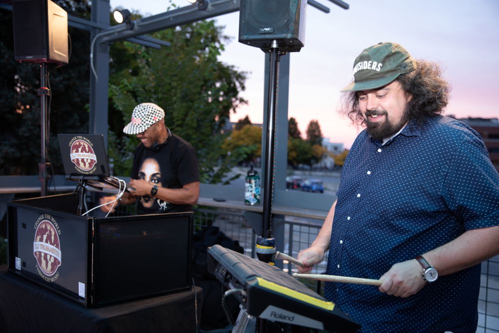 Two guys banging on drums