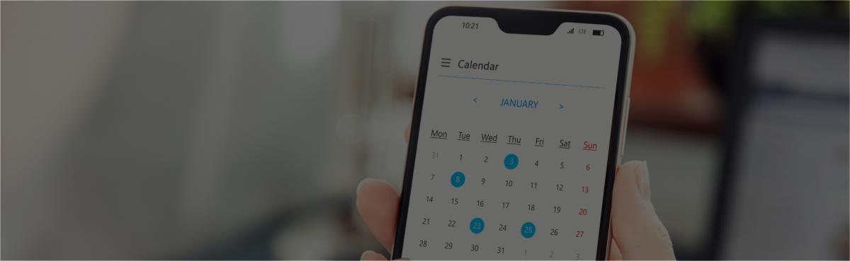 Hand holding phone with calendar app showing