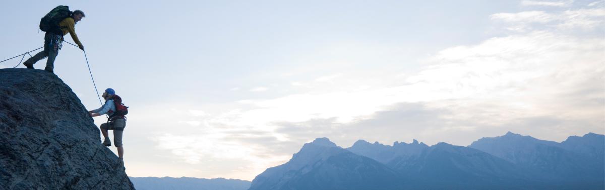 Couple mountain climbing on a high peak