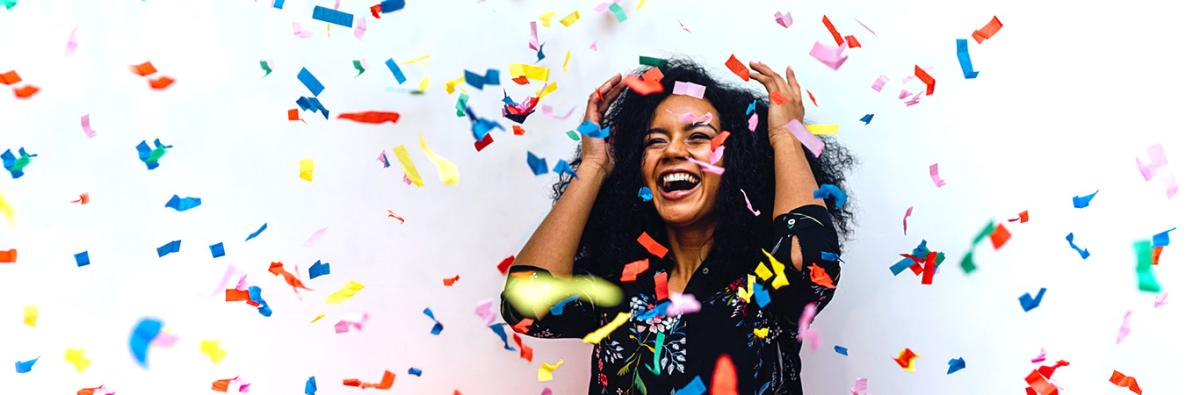 Woman standing in middle of downpouring confetti