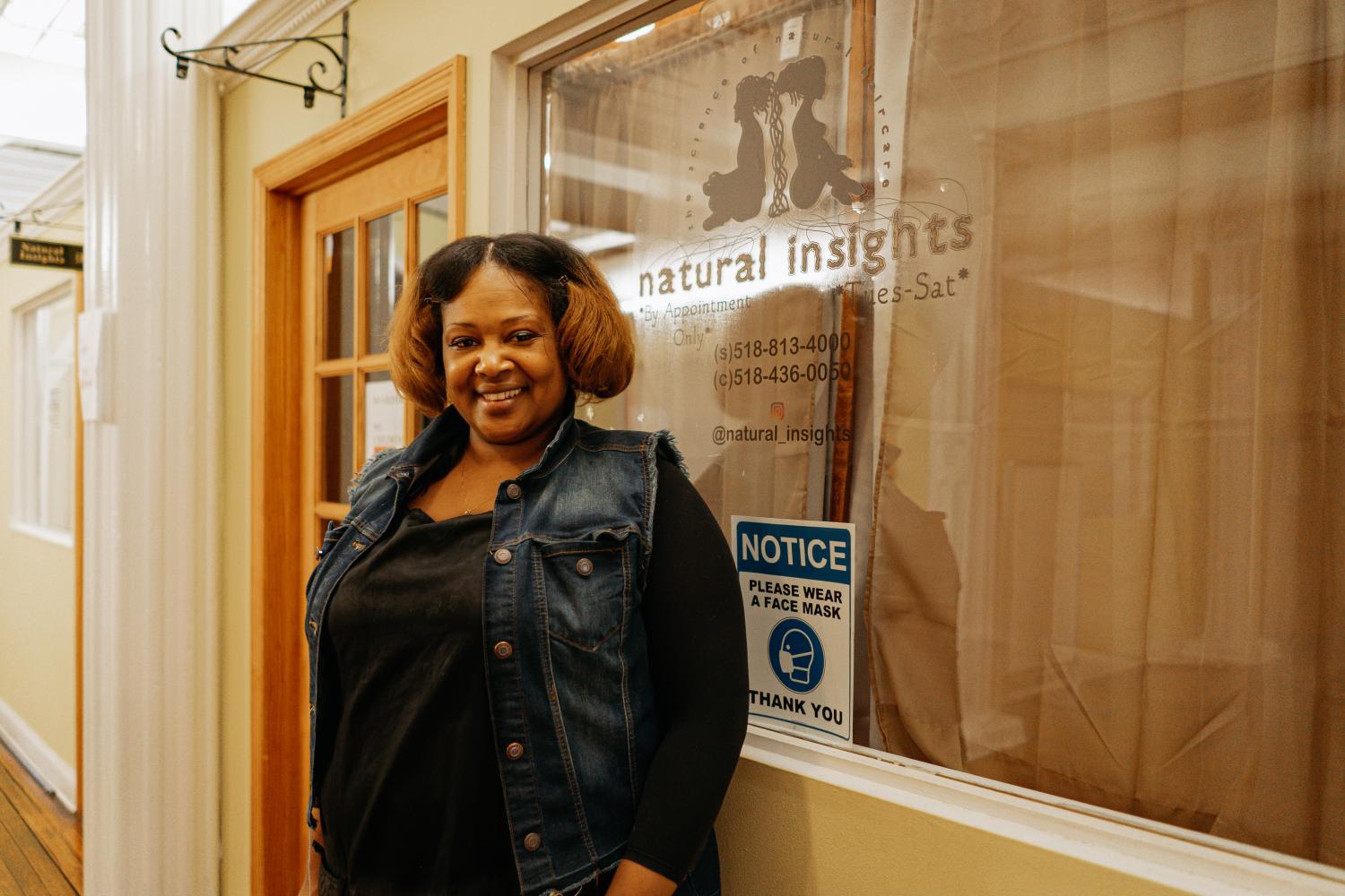 exterior view of Natural insights with an employee standing next to sign saying Natural Insights