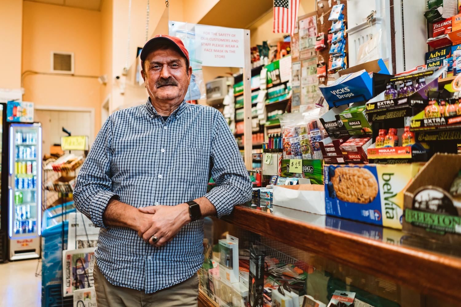 man leaning on store countertop