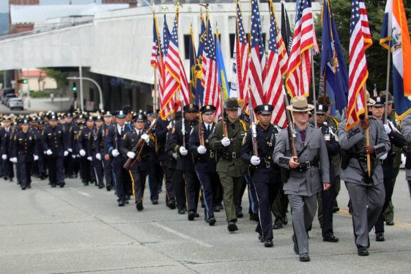 Police officers in uniform marching in procession with flags
