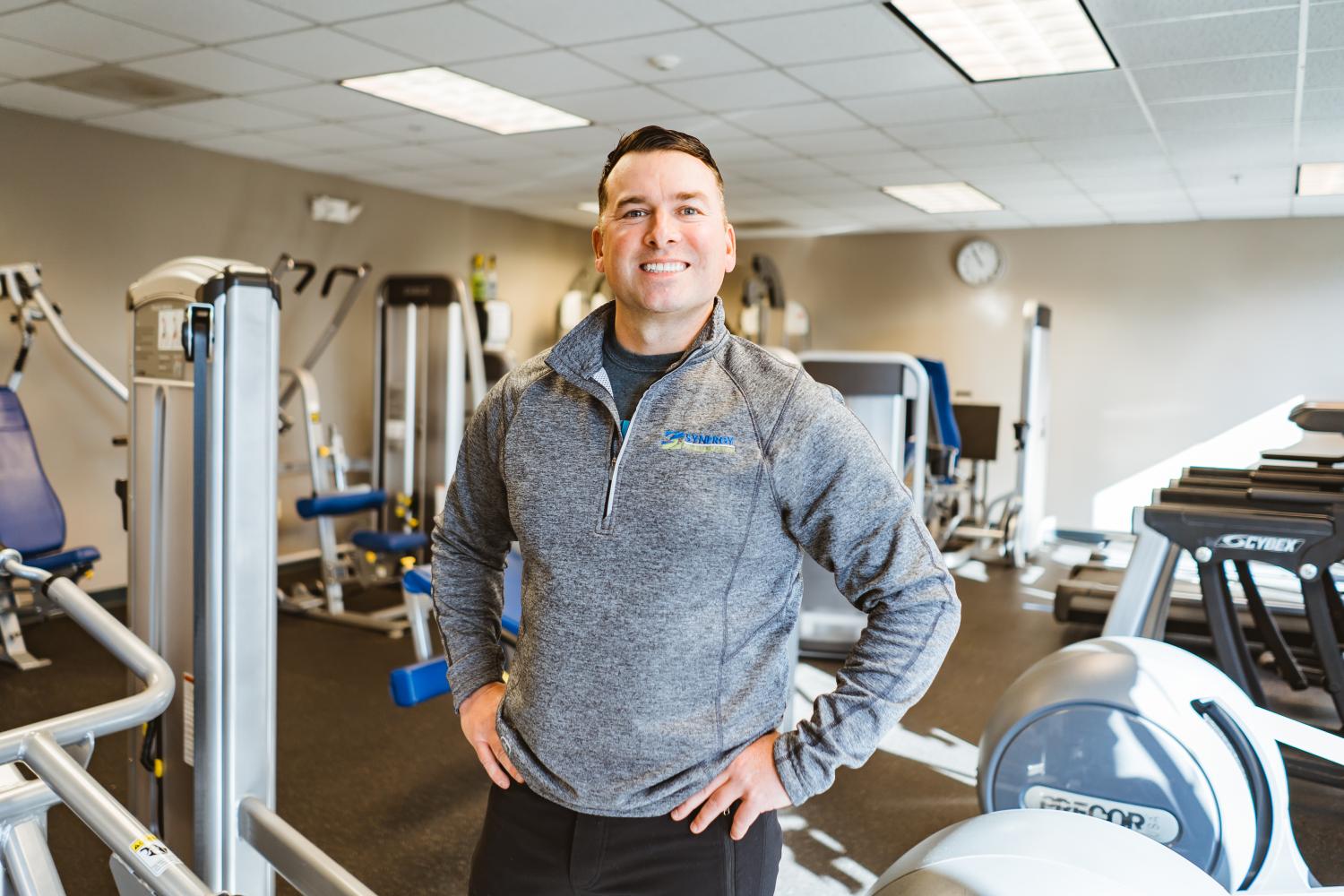 interior view with exercise equipment with a man with a smile