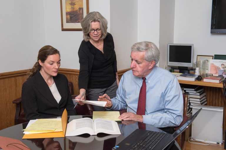 Lawyers with law books and legal papers in office