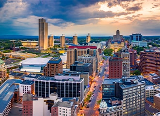 Fisheye lens photo of Albany at twilight showing buildings on State Street with Empire State Plaza in background