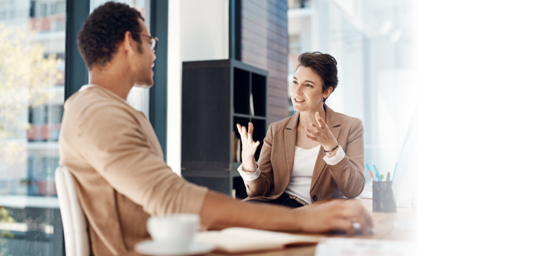 Man and woman talking animatedly in office