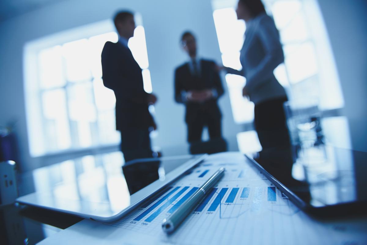 coworkers in silhouette in office with charts in foreground