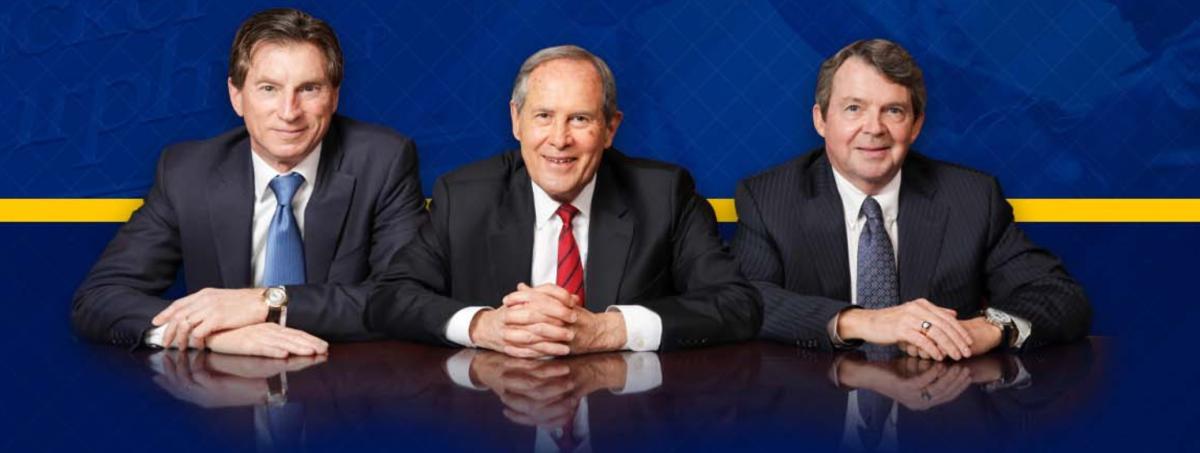 Three lawyers with hands folded on table