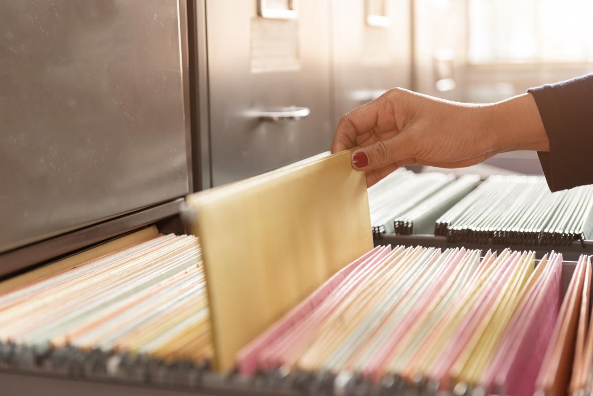 Female hand pulling hanging file out of drawer