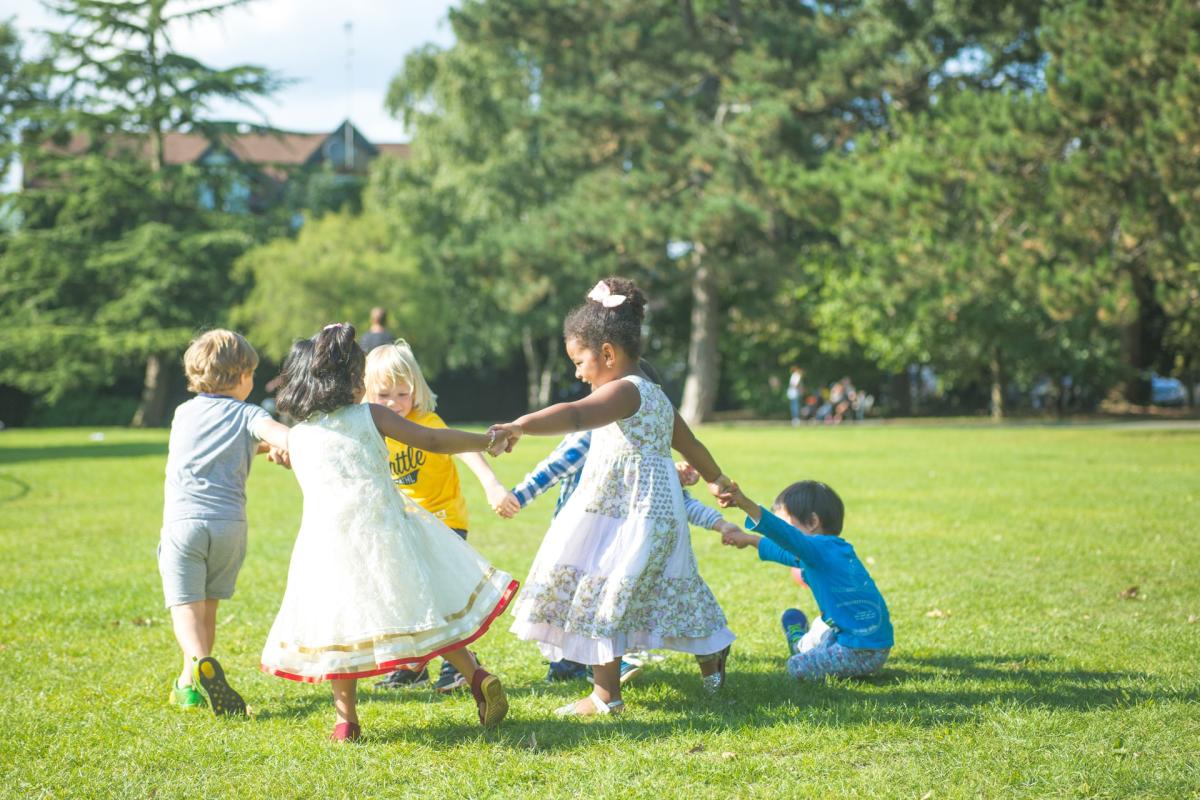 Children holding hands, playing in park