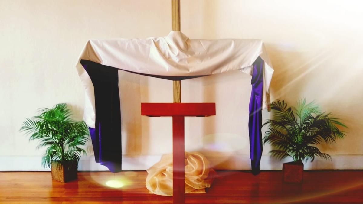 Pulpit with plants, cross, and draped garment