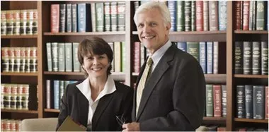 Woman and man in front of bookshelf full of law books