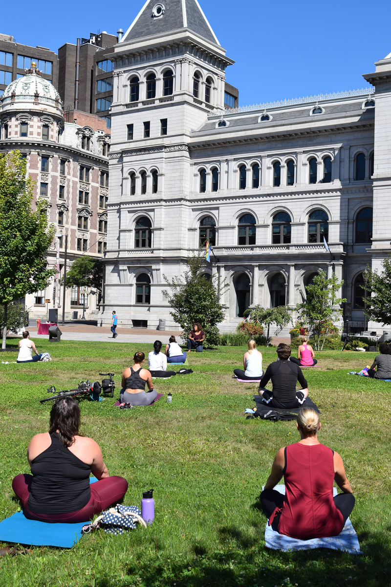People on yoga mats in front of SUNY Plaza