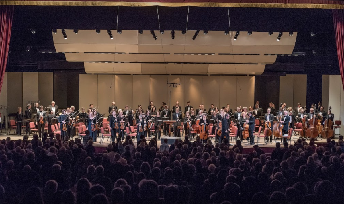 Albany Symphony on stage standing after performance with live audience