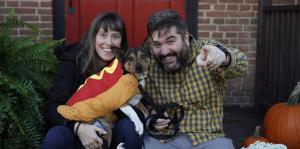 man and woman hold dog and look at camera