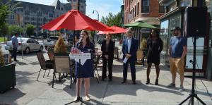 People stand on street for announcement of new bus pass program