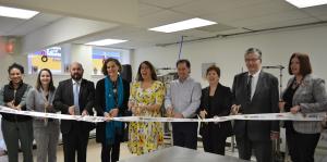 People stand in row and hold scissors at ribbon cutting ceremony