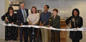 People stand in row at ribbon cutting ceremony