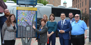 City and state officials standing outside wayfinding signage