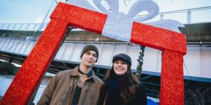 Two people in front of a christmas present display