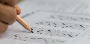 Hand holding pencil filling in test answers