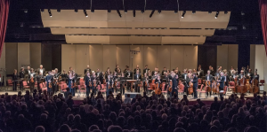 Albany Symphony on stage standing after performance with live audience