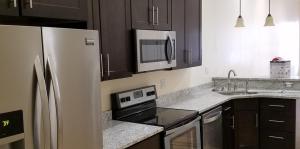 Kitchen View with counter top, cupboards, sink, stove, refrigerator