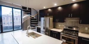 Kitchen with large windows and stainless steel appliances, island sink