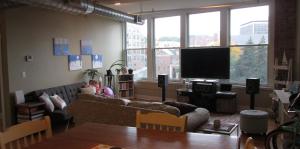 view of living area with TV, couch, table, chairs, plants, etc.  