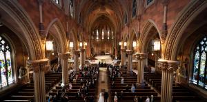 Wedding in large cathedral with arches and columns and stained glass windows