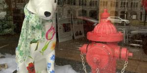 Dog Statue in a St. patrick day hat next to fire hydrant