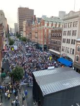 Roof of stage shown with on-street crowd facing the stage