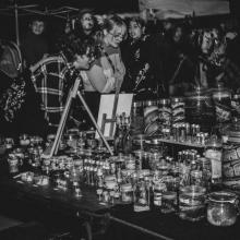 People peruse jars on table at outdoor market