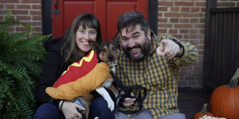 Man and woman look at camera while holding dog