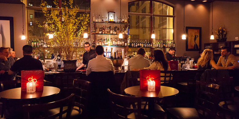 People sitting around an elegant bar.