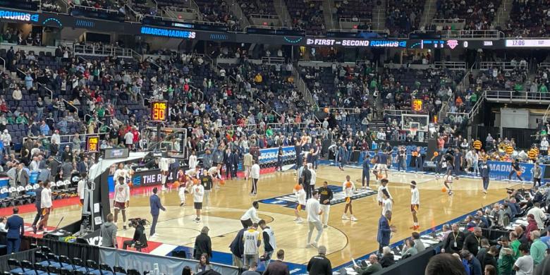 Basketball game takes place with crowd looking on